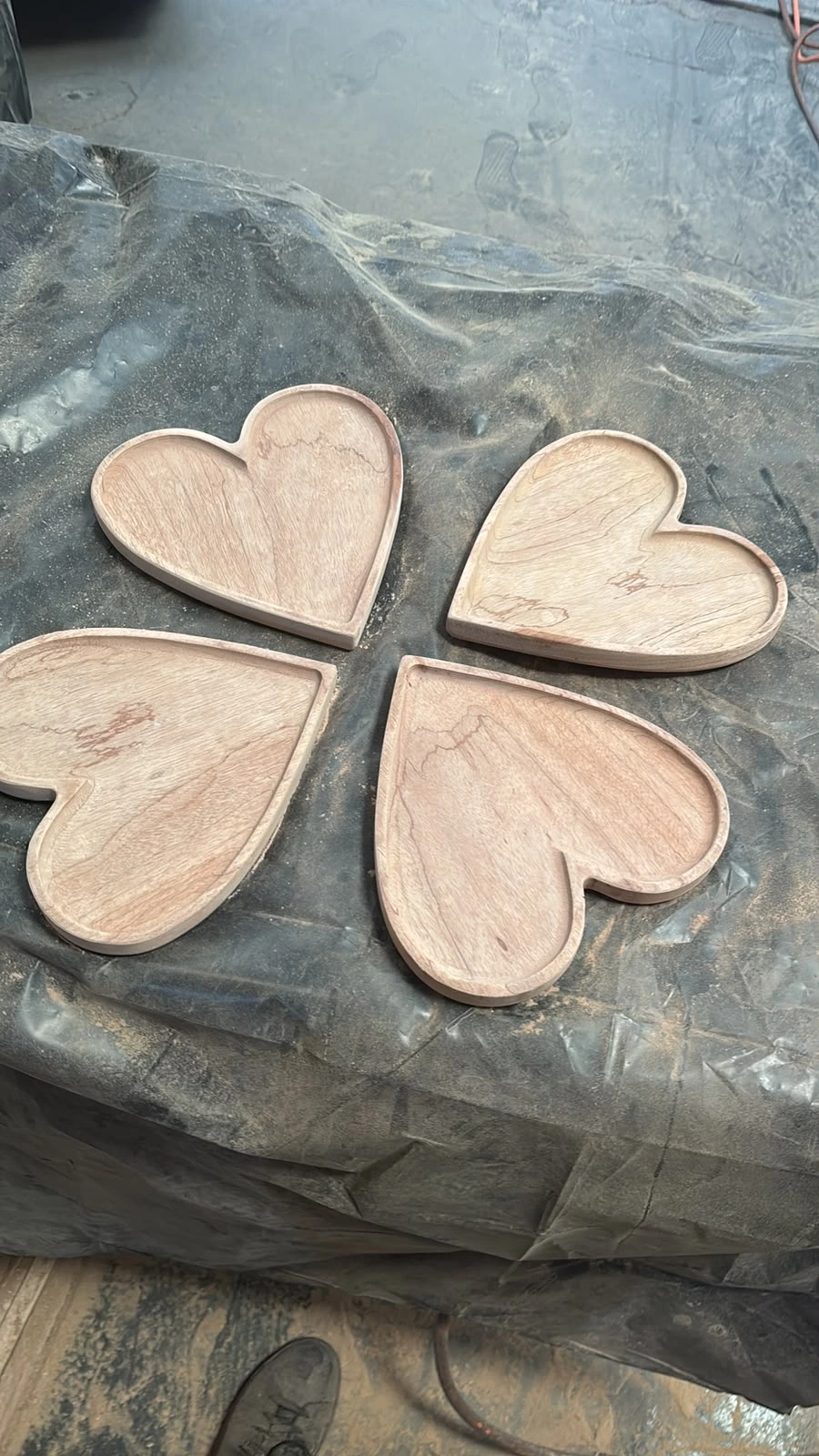 Cuatro charolas de madera en forma de corazón recién maquinadas