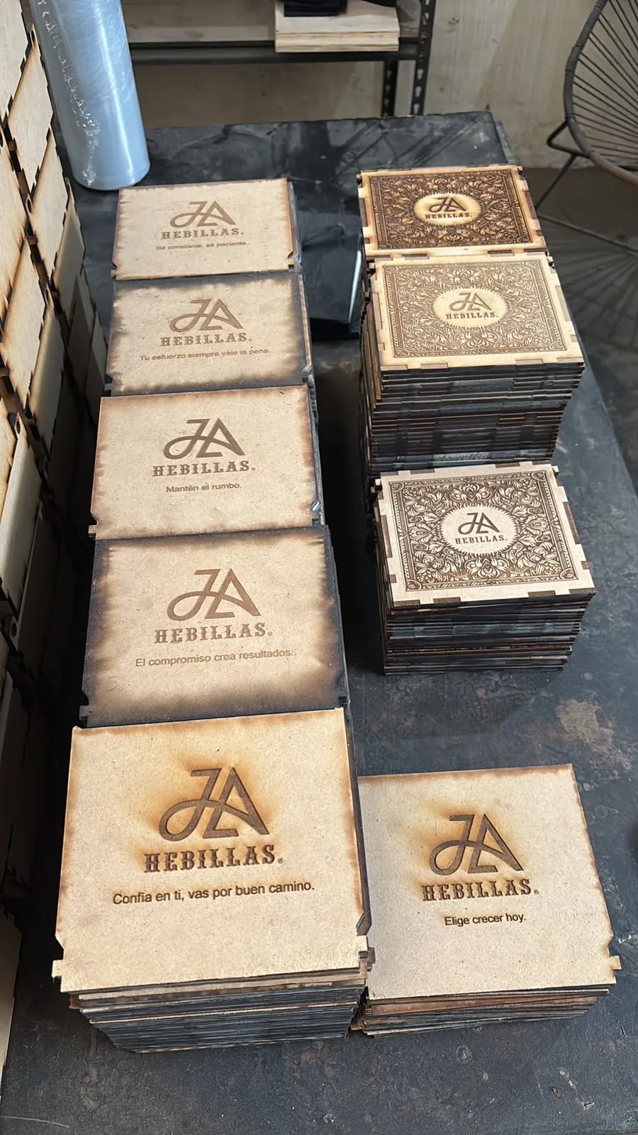 Pilas de cajas de MDF grabadas con logotipo y frases distintas